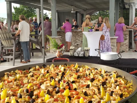 Seafood paella served on a patio at an evening party