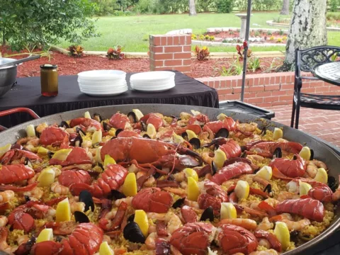 Lobster and seafood paella on a brick patio at a garden party