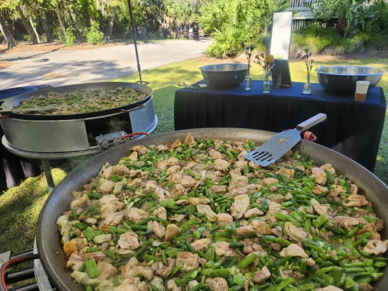 Chicken and green bean paella cooking at an outdoor garden event